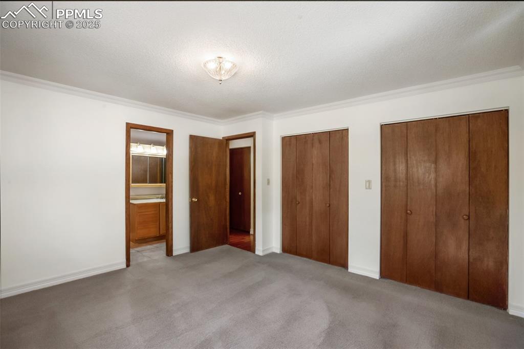 Image 11 of 36: Primary bedroom with door adjoining bathroom