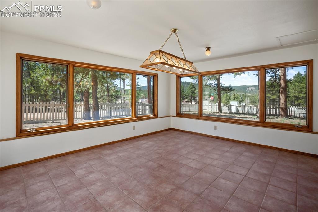 Image 17 of 36: Lower level sunroom with ample natural light