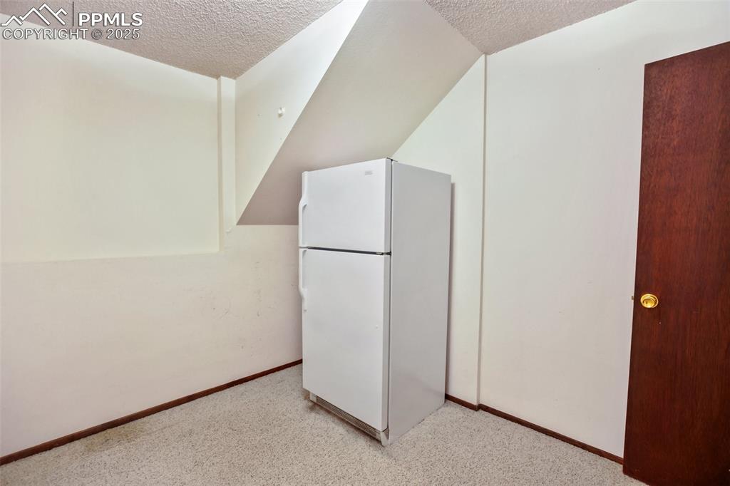 Image 26 of 36: Storage room with refrigerator