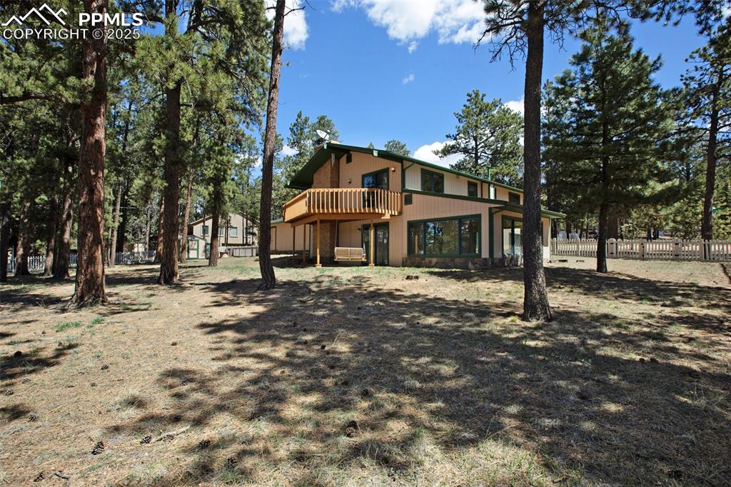 Image 28 of 36: Rear view of house with a wooden deck