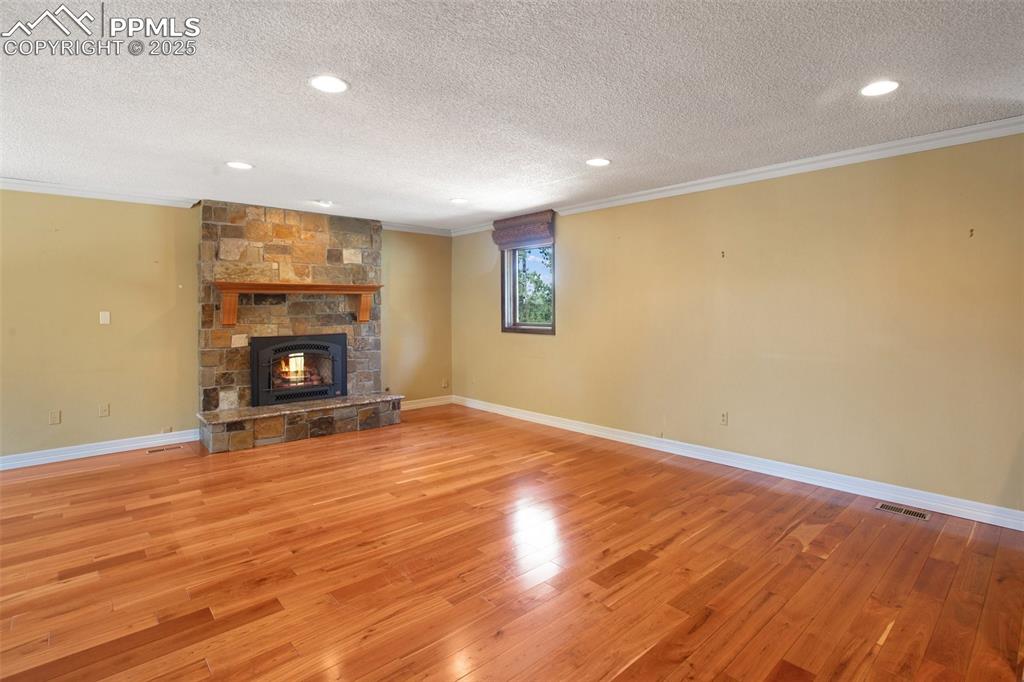 Image 3 of 36: Unfurnished living room featuring crown molding, a textured ceiling, visibl