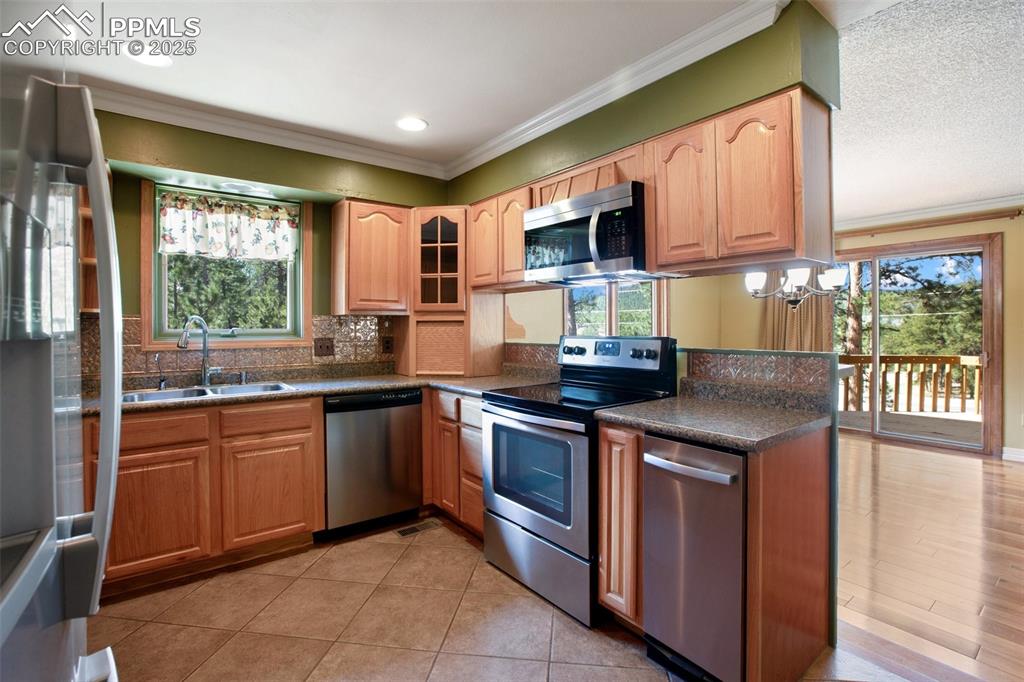 Image 8 of 36: Kitchen featuring crown molding, a healthy amount of sunlight, stainless st