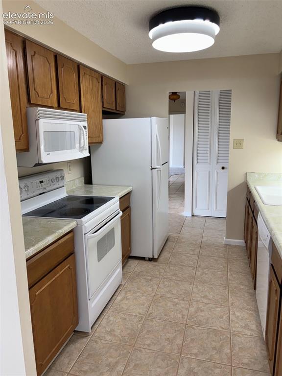 Image 2 of 24: galley kitchen has access to the dining room and front entry