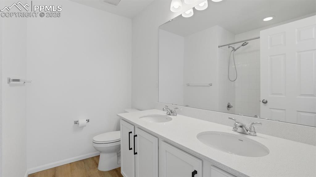 Image 22 of 45: The upper level Full Bathroom features a dual sink vanity, mirror, and tile