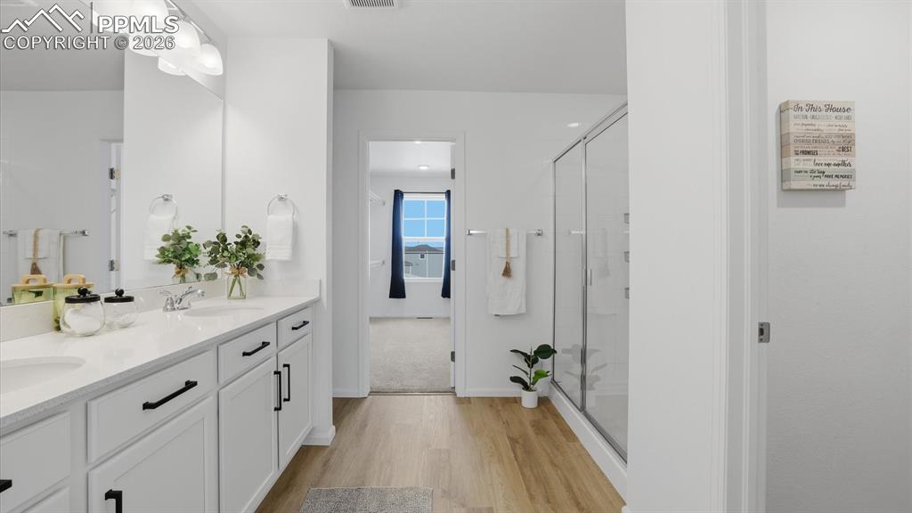 Image 30 of 45: Upper Level Primary Bathroom with dual sink vanity, mirror, luxury vinyl pl