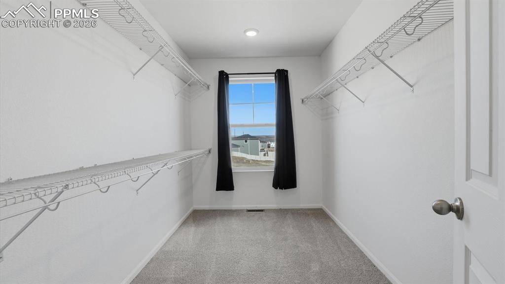 Image 33 of 45: Huge walk in closet with built-in racks and window in the Primary Bedroom.
