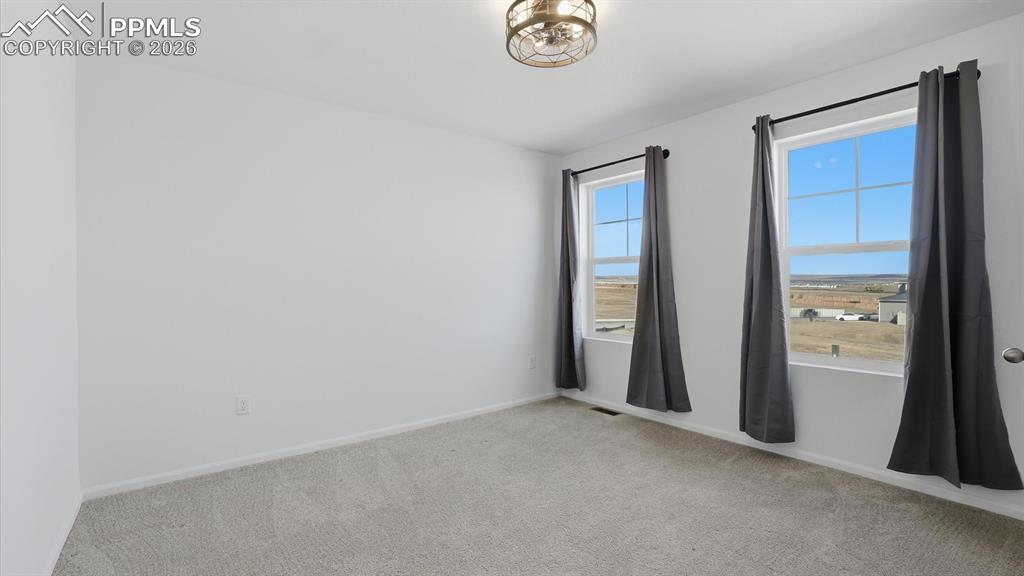 Image 34 of 45: Upper Level Bedroom #2 with neutral carpet, a lighted ceiling fan, and doub