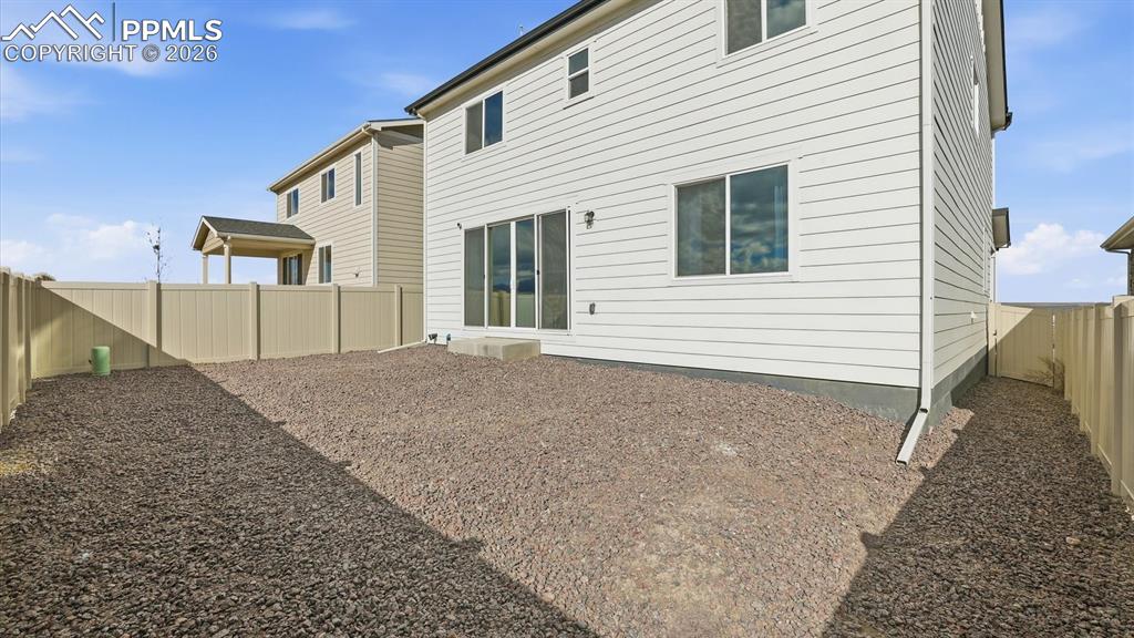 Image 45 of 45: Rear view of back of home and fenced yard.