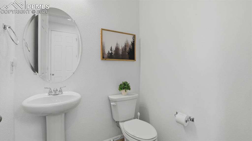 Image 9 of 45: Powder Bathroom with pedestal sink and round mirror.