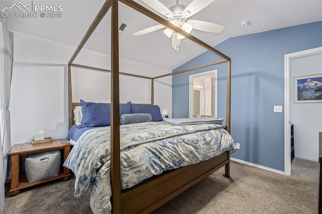 Image 10 of 22: Bedroom featuring light colored carpet, vaulted ceiling, and walk in closet