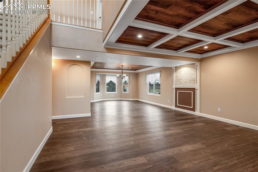 Image 13 of 46: Unfurnished living room featuring a chandelier, dark wood finished floors, 