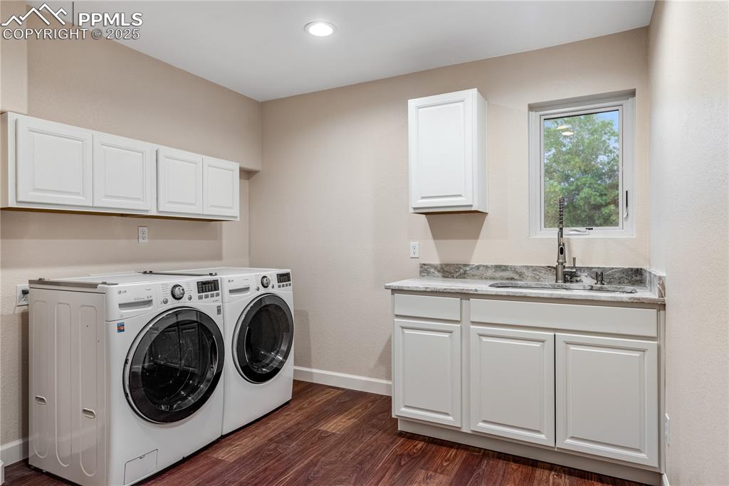 Image 24 of 46: Laundry room with independent washer and dryer, dark wood-style flooring, c