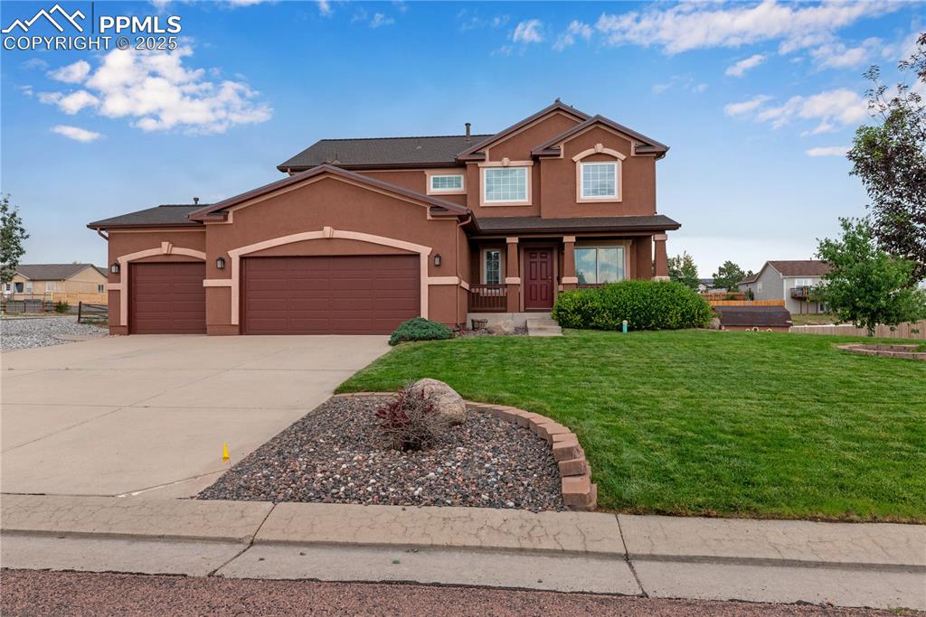 Image 3 of 46: View of front of property featuring a garage, stucco siding, a front yard, 