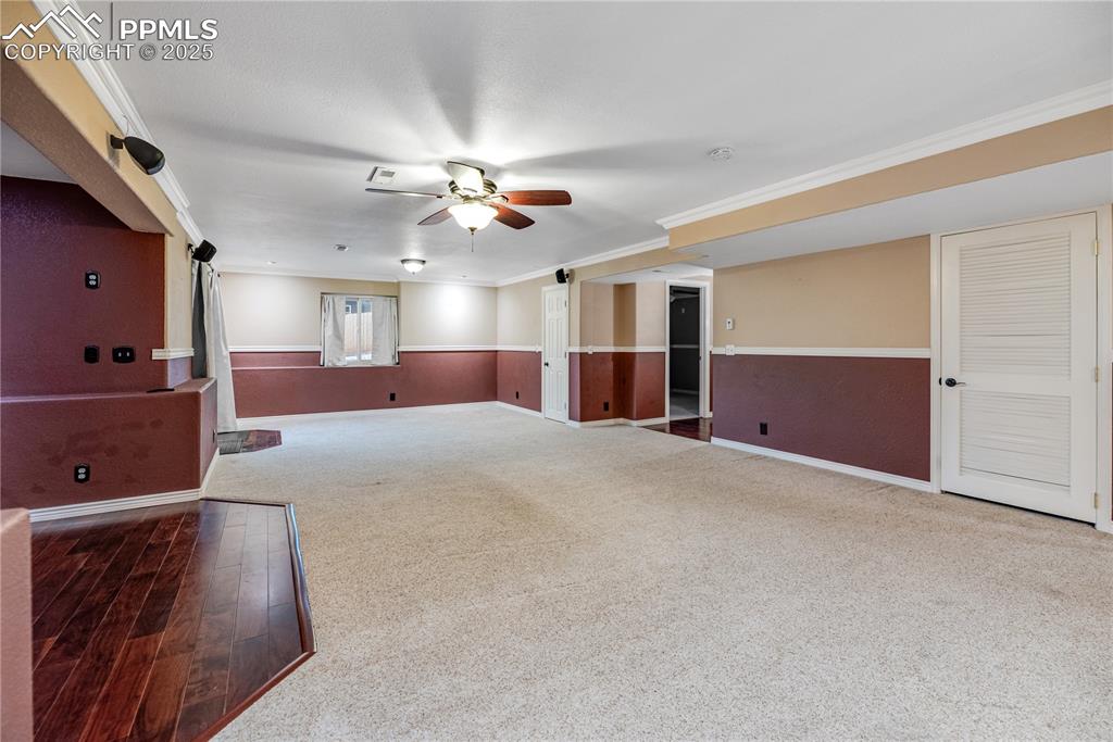 Image 30 of 46: Unfurnished room featuring ceiling fan, carpet, and crown molding