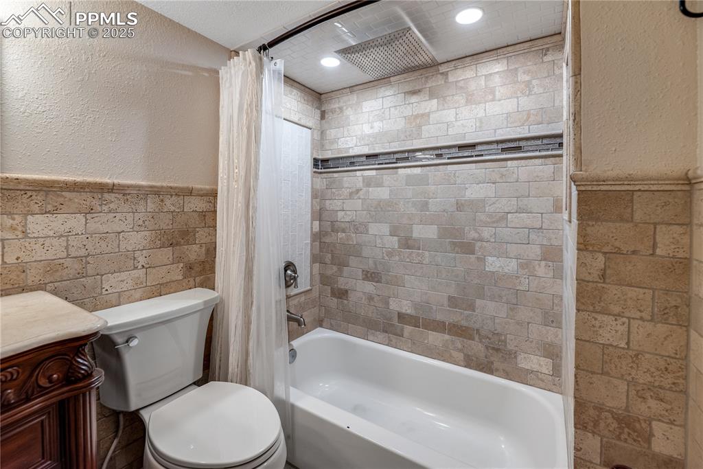 Image 34 of 46: Bathroom featuring wainscoting, shower / tub combo with curtain, vanity, an
