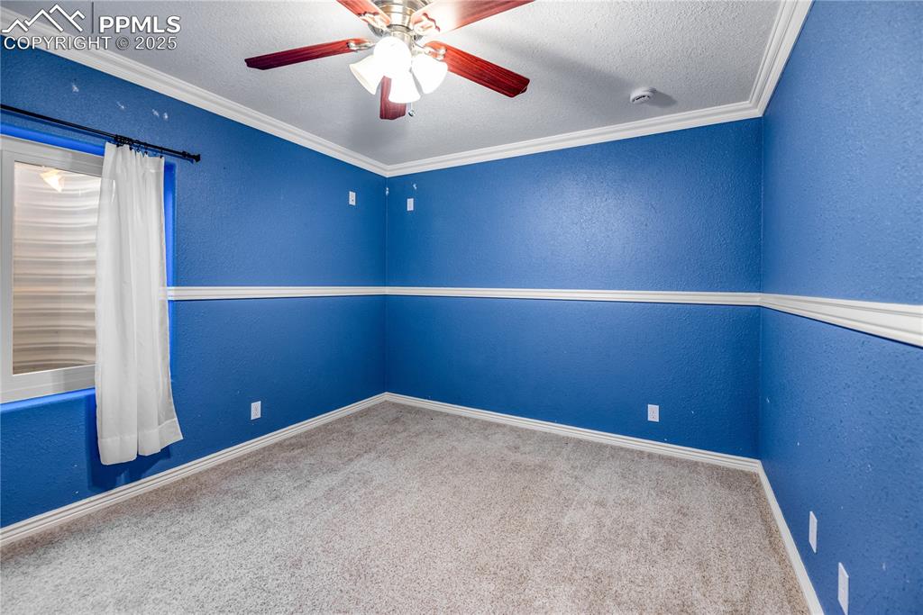 Image 35 of 46: Unfurnished room with carpet, a ceiling fan, a textured ceiling, a textured