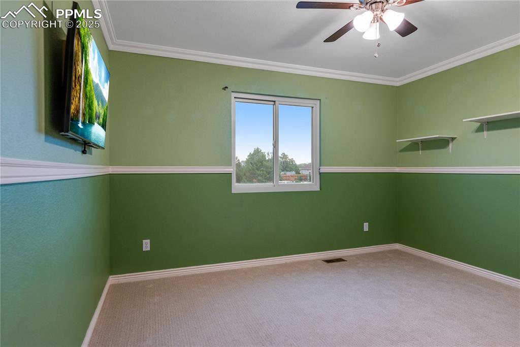 Image 39 of 46: Carpeted empty room featuring a ceiling fan and ornamental molding