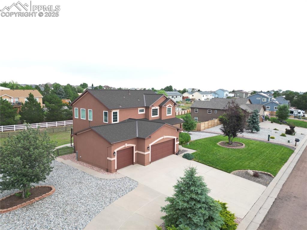 Image 5 of 46: Traditional-style house with a residential view, stucco siding, concrete dr