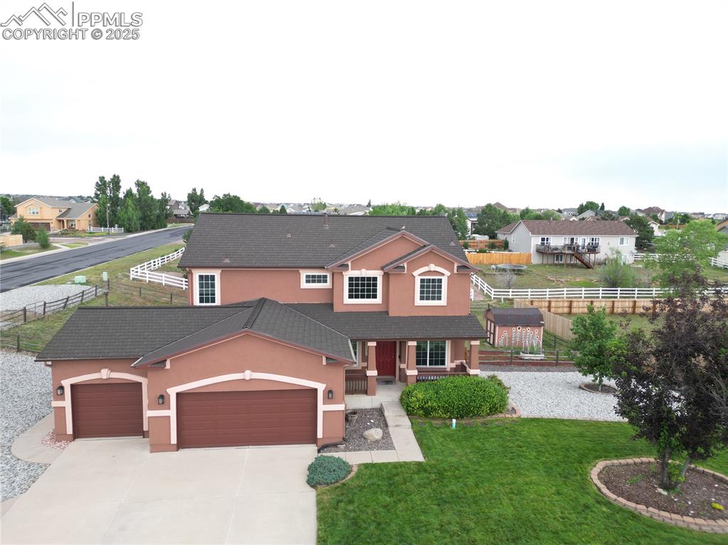 Image 6 of 46: View of front of house with stucco siding, an attached garage, driveway, an