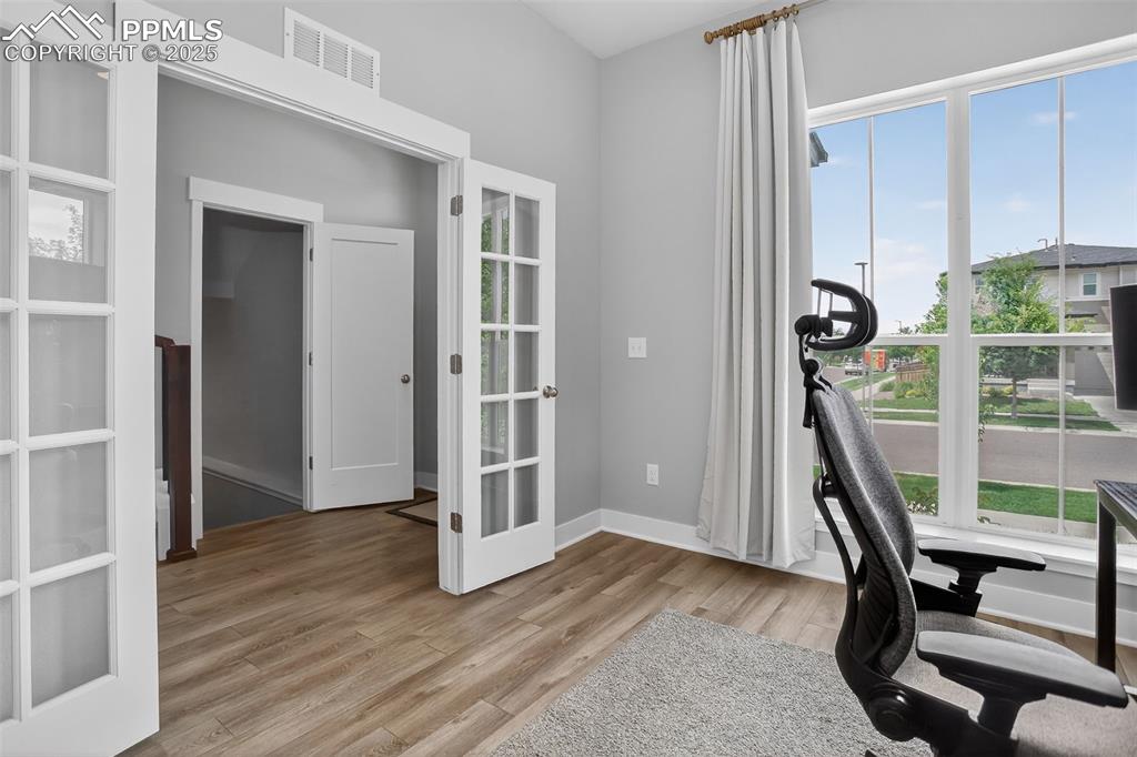 Image 17 of 50: Main level office with beautiful french doors and huge picture window lets 