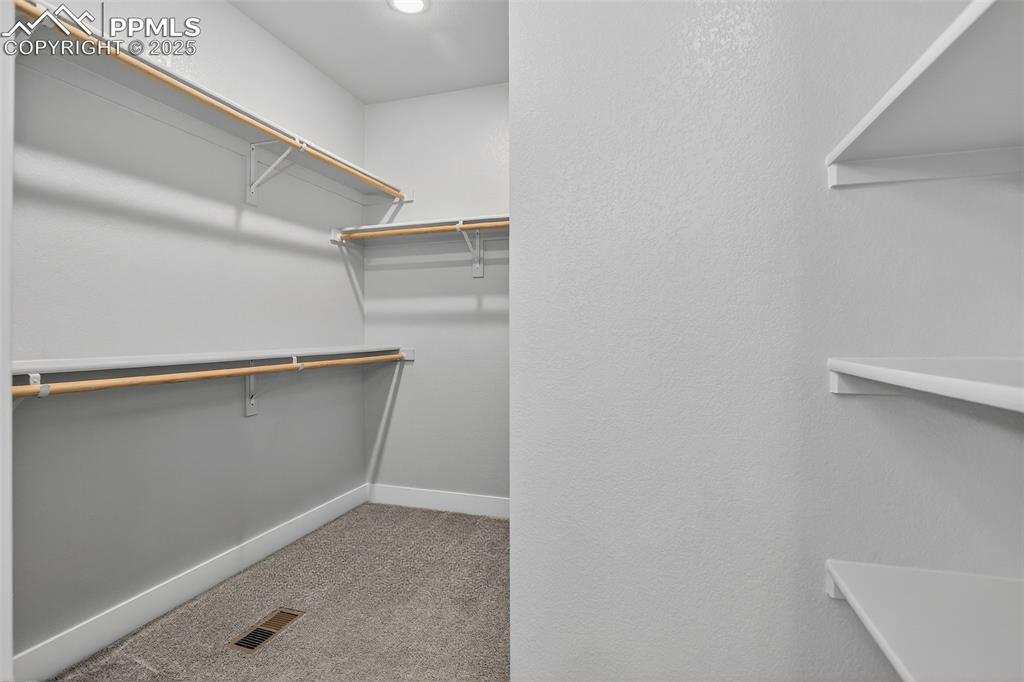 Image 27 of 50: Large primary closet, with plenty of upgraded shelves and rods for your bes