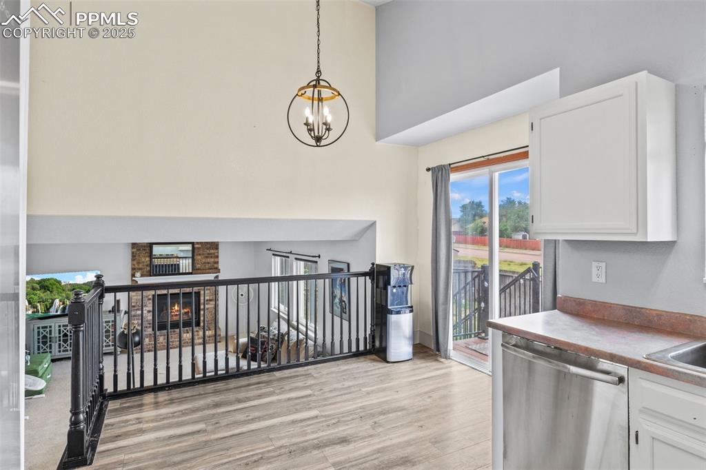 Image 13 of 35: Kitchen featuring dishwasher, light wood-type flooring, white cabinetry, a