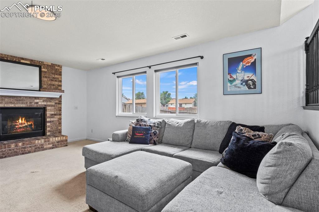 Image 16 of 35: Living room featuring carpet flooring and a brick fireplace