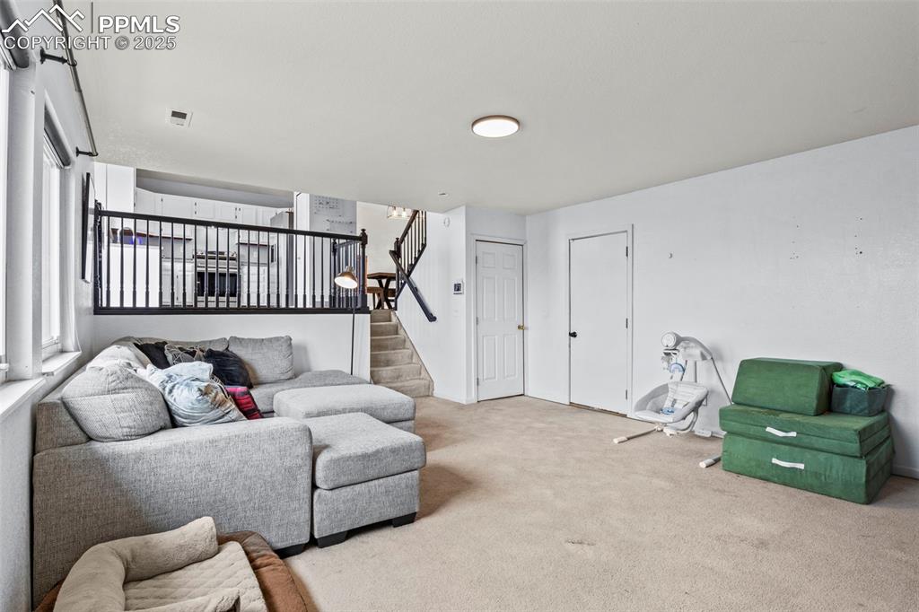 Image 18 of 35: Carpeted living room featuring stairs