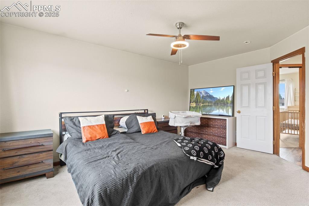 Image 20 of 35: Carpeted bedroom with a ceiling fan