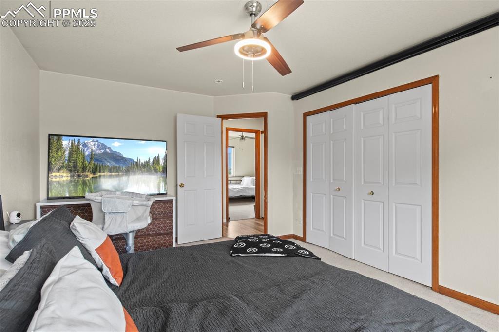 Image 21 of 35: Carpeted bedroom featuring a ceiling fan and a closet