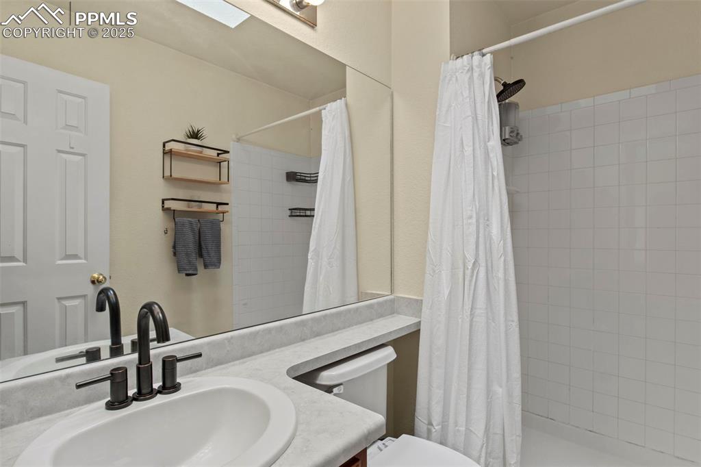 Image 24 of 35: Full bathroom featuring vanity and tiled shower
