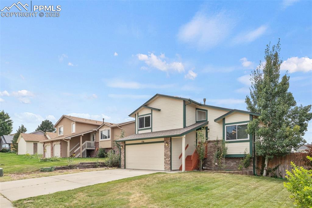 Image 4 of 35: View of front of home featuring an attached garage, concrete driveway, bric