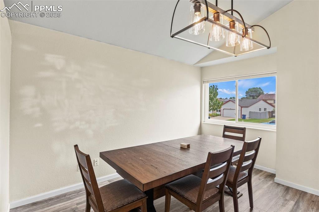 Image 7 of 35: Dining room with lofted ceiling and wood finished floors