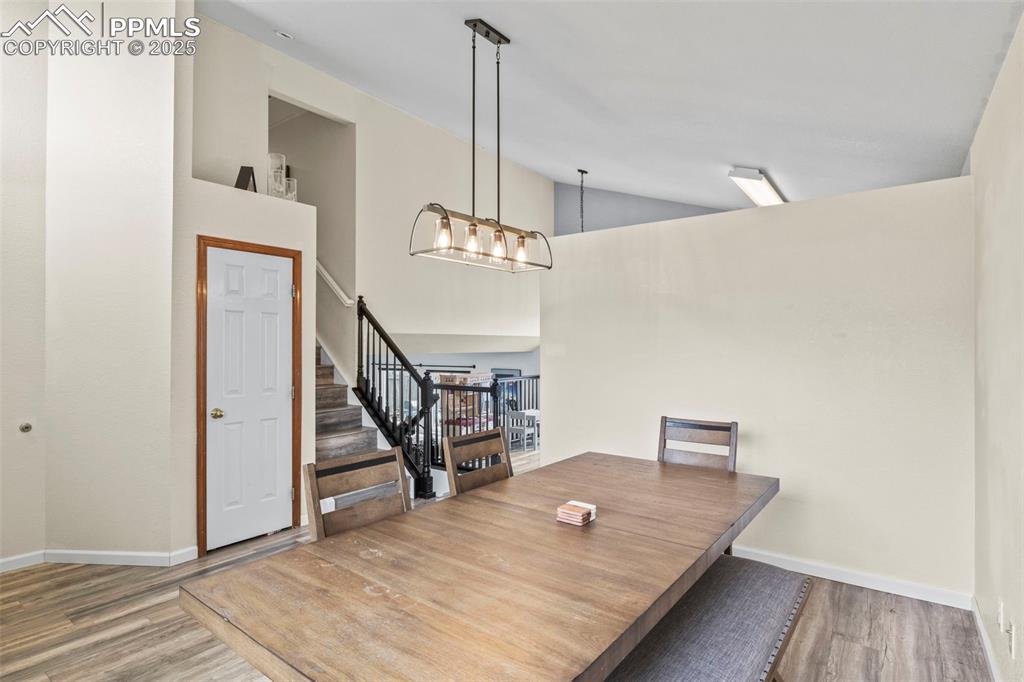 Image 8 of 35: Unfurnished dining area featuring stairway, wood finished floors, and high