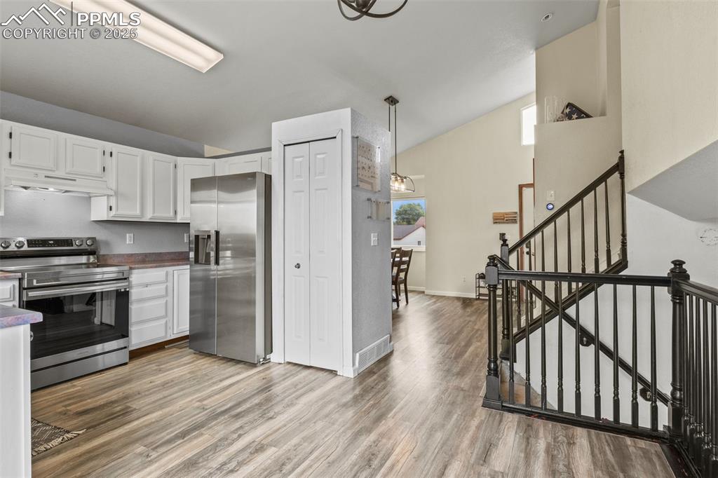Image 9 of 35: Kitchen with appliances with stainless steel finishes, white cabinetry, lof