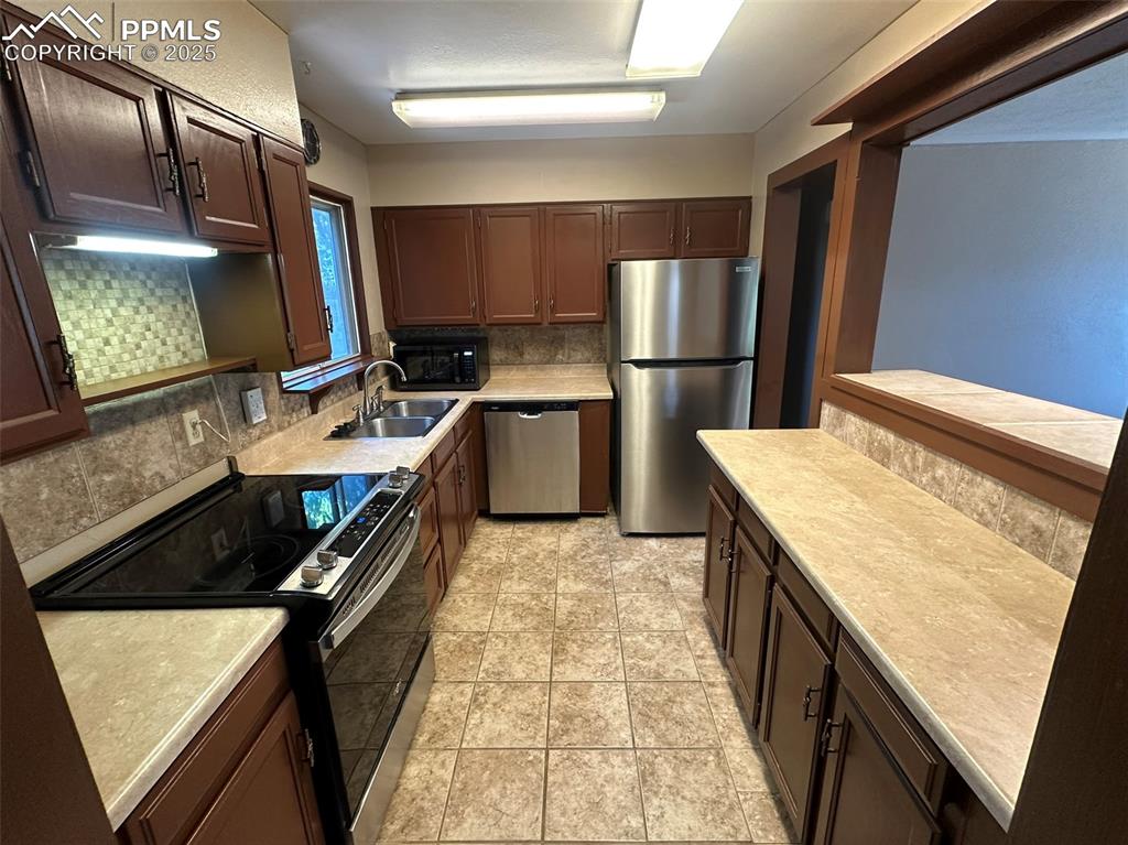 Image 12 of 27: Kitchen featuring newer stainless steel appliances, light countertops, tast