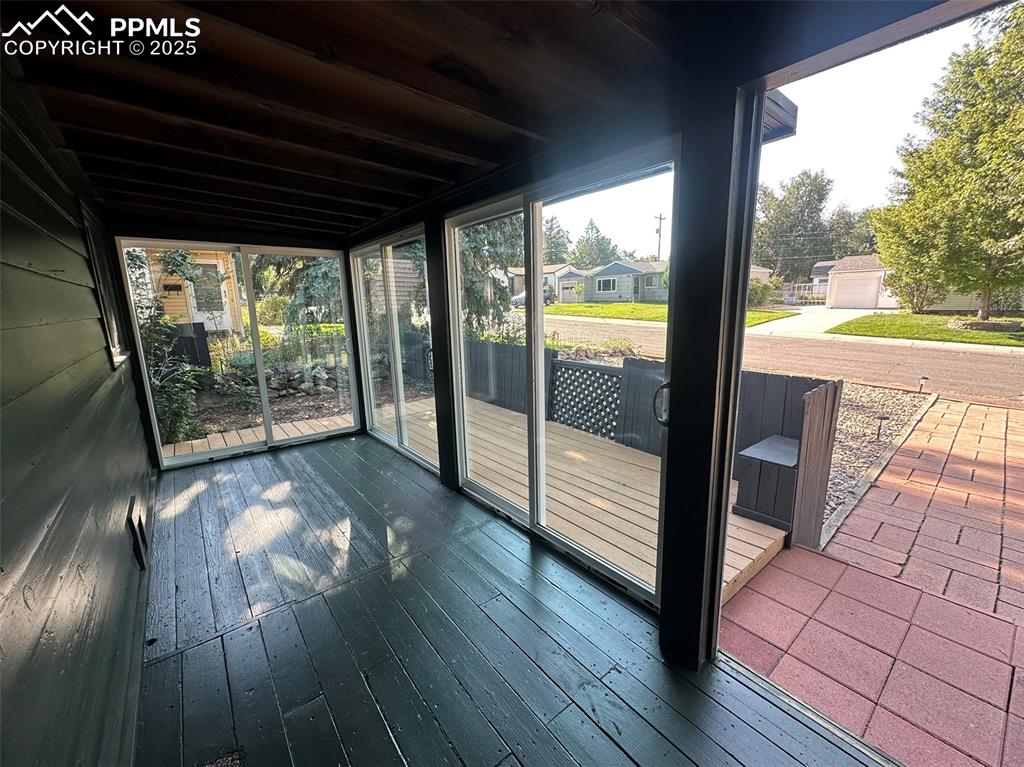 Image 6 of 27: Sunroom with 3 Pella sliding doors opening up to deck
