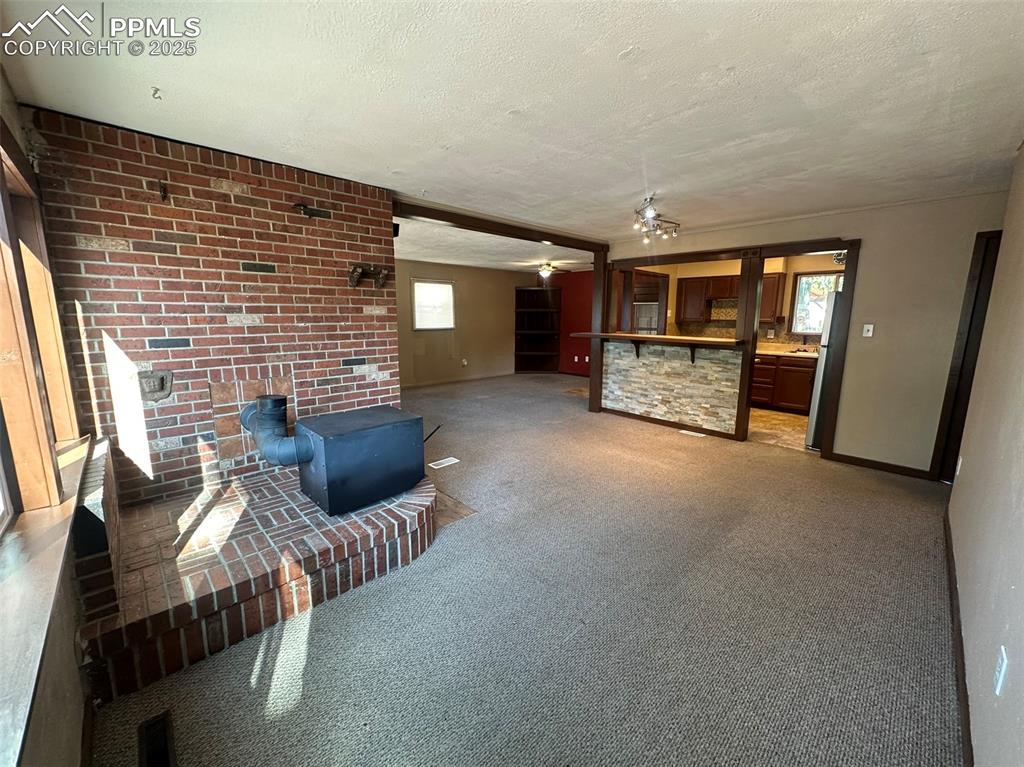 Image 8 of 27: Carpeted living area with plenty of natural light