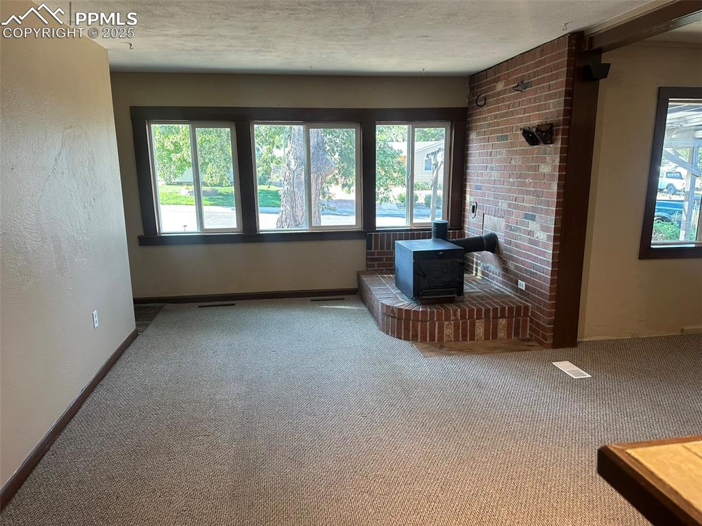 Image 9 of 27: Living room featuring a wood stove