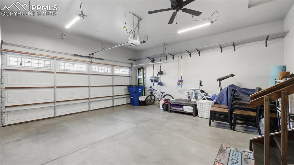 Image 36 of 42: 2-car attached garage with door opener and lighted ceiling fan.