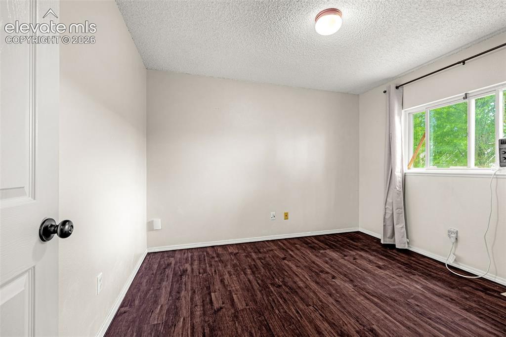 Image 10 of 15: Bright bedroom featuring luxury vinyl wood-look flooring, white walls, and 