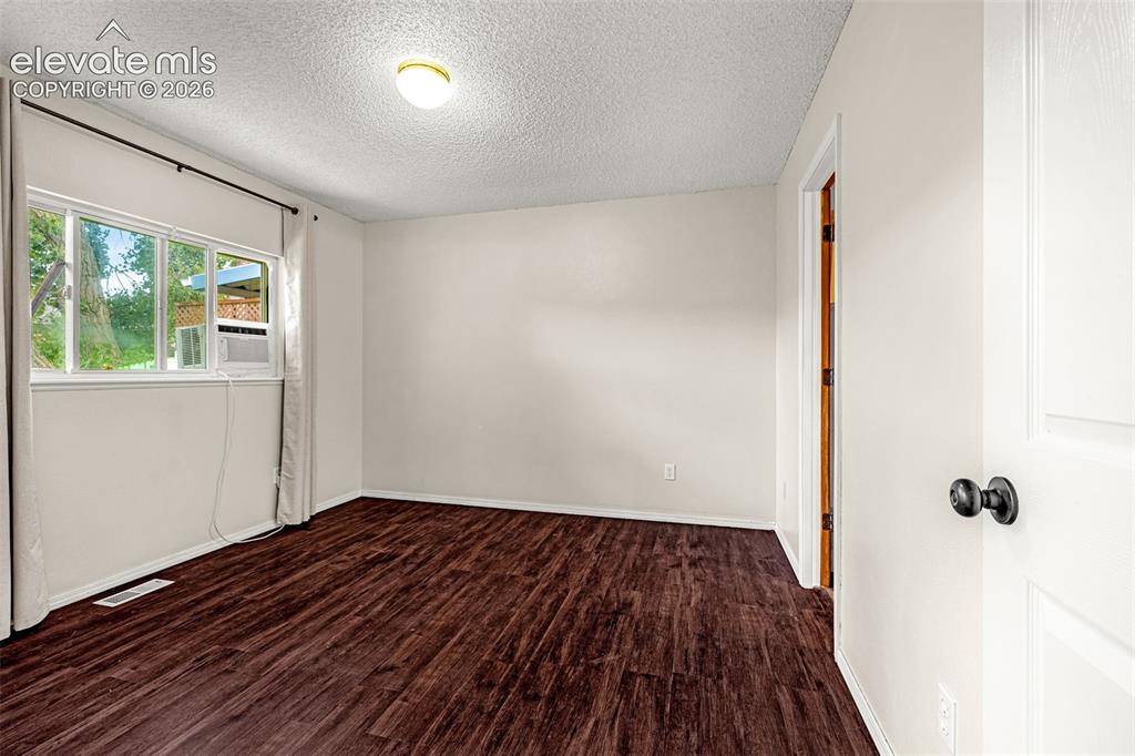 Image 7 of 15: Bedroom featuring wood-finish flooring, a bright window, and a ceiling-moun