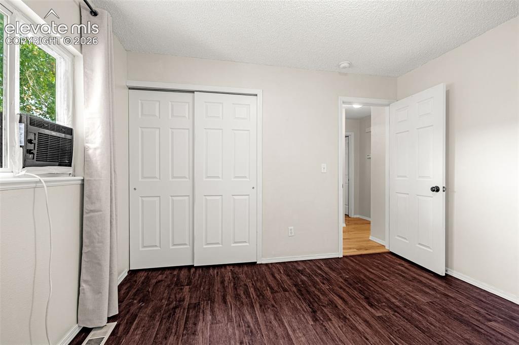 Image 9 of 15: Bedroom featuring luxury vinyl flooring, light-colored walls, and a window 