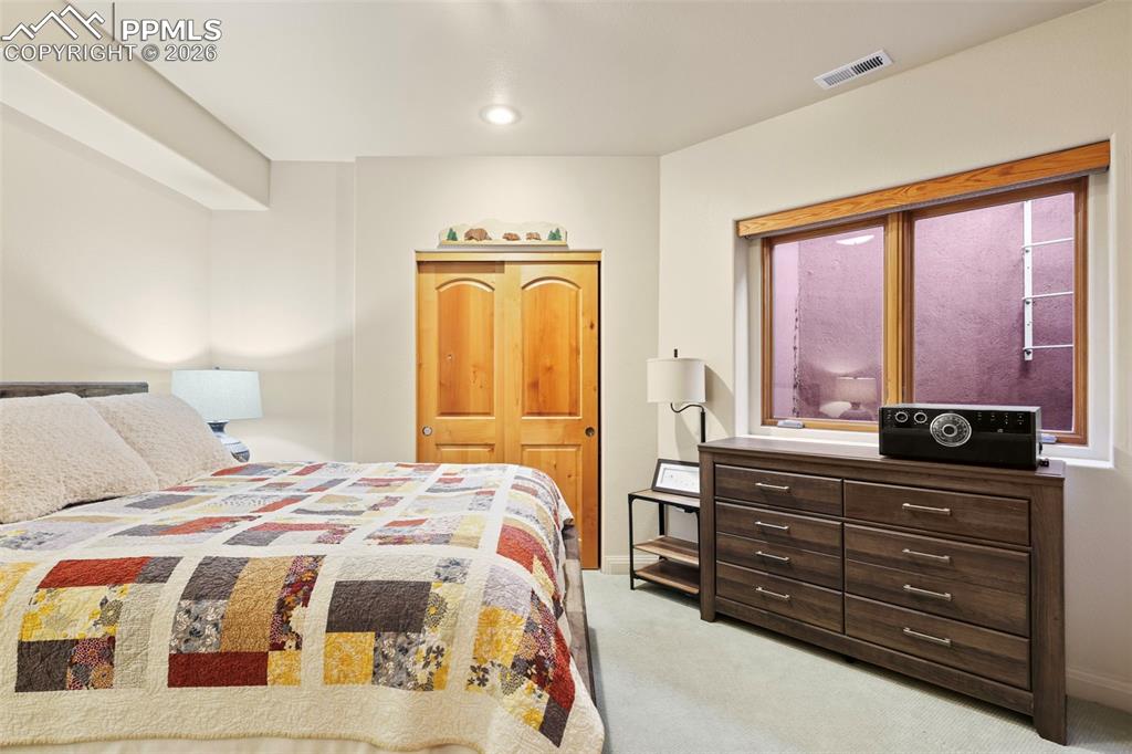 Image 14 of 19: Bedroom with light colored carpet and a closet