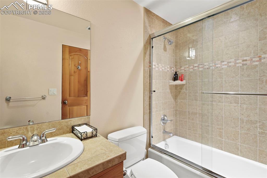 Image 20 of 28: Lower level Full bathroom with vanity and enclosed tub / shower combo