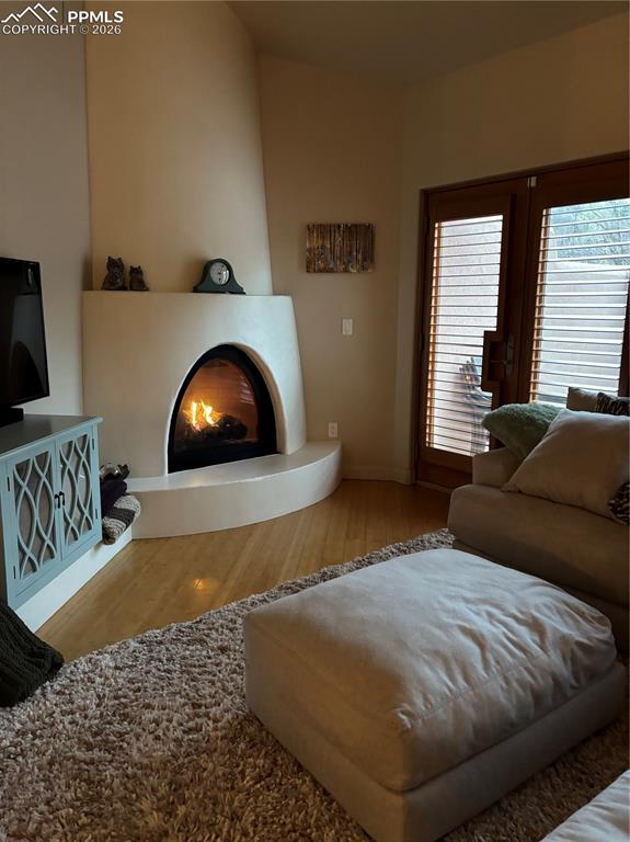 Image 27 of 28: Living room with light wood bamboo flooring and a large southwest fireplace