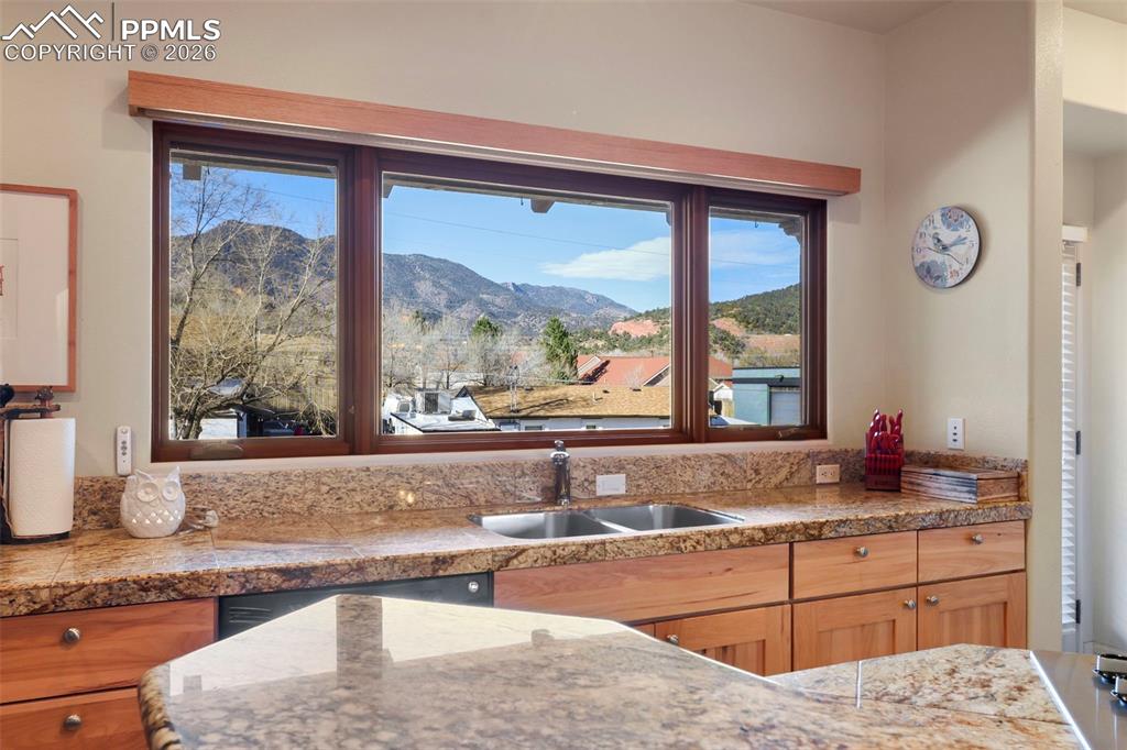 Image 5 of 19: Kitchen with a mountain view, light stone counters, and stainless steel sto