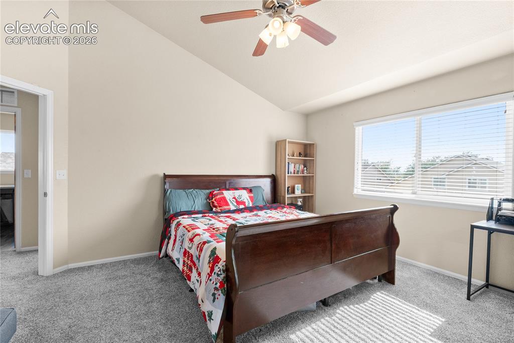Image 19 of 41: Spacious room featuring vaulted ceilings, a ceiling fan, plush carpet floor