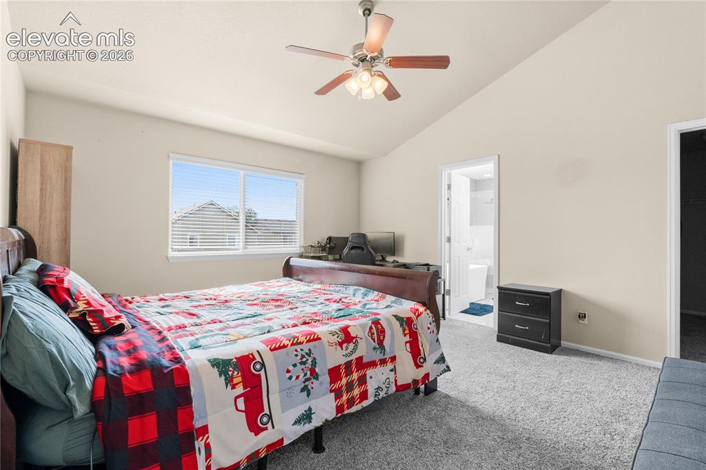Image 20 of 41: Spacious room featuring vaulted ceilings, a ceiling fan with light fixture,
