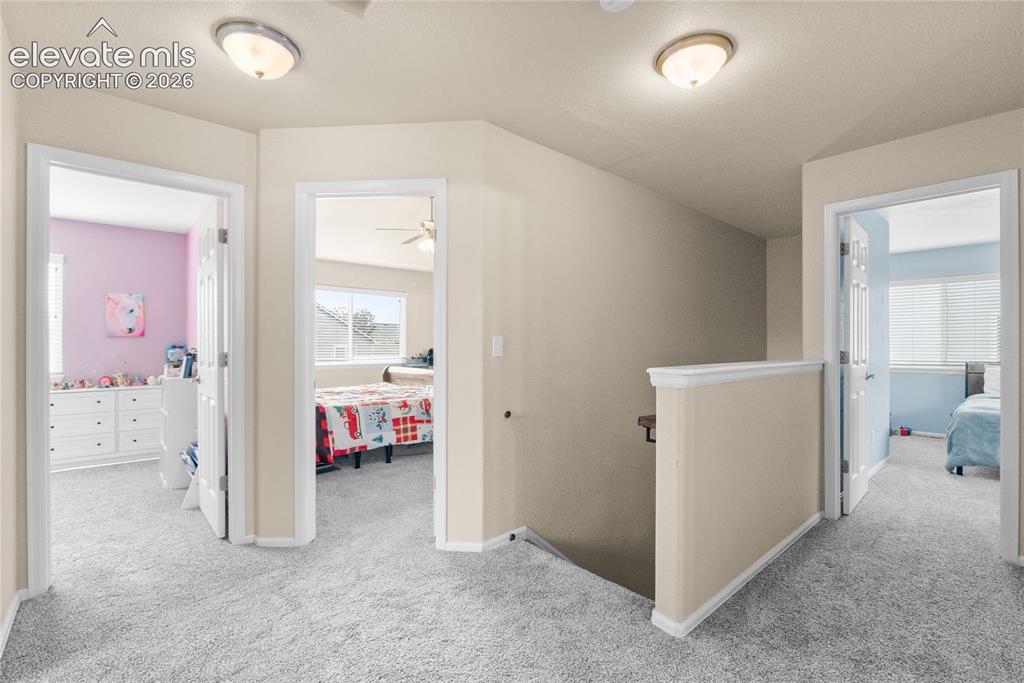 Image 22 of 41: Upper-level hallway featuring light-toned walls, white trim, and neutral ca